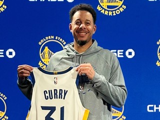 Seth Curry pózuje s dresom Golden State Warriors.