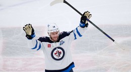 Center tímu Winnipeg Jets Jonathan Toews máva divákom počas zápasu NHL na ľade Chicago Blackhawks.