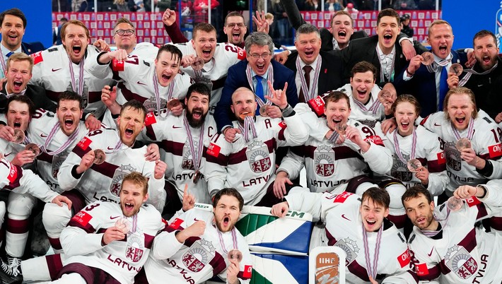 Lotyšskí hokejisti oslavujú zisk bronzu na MS v hokeji 2023.