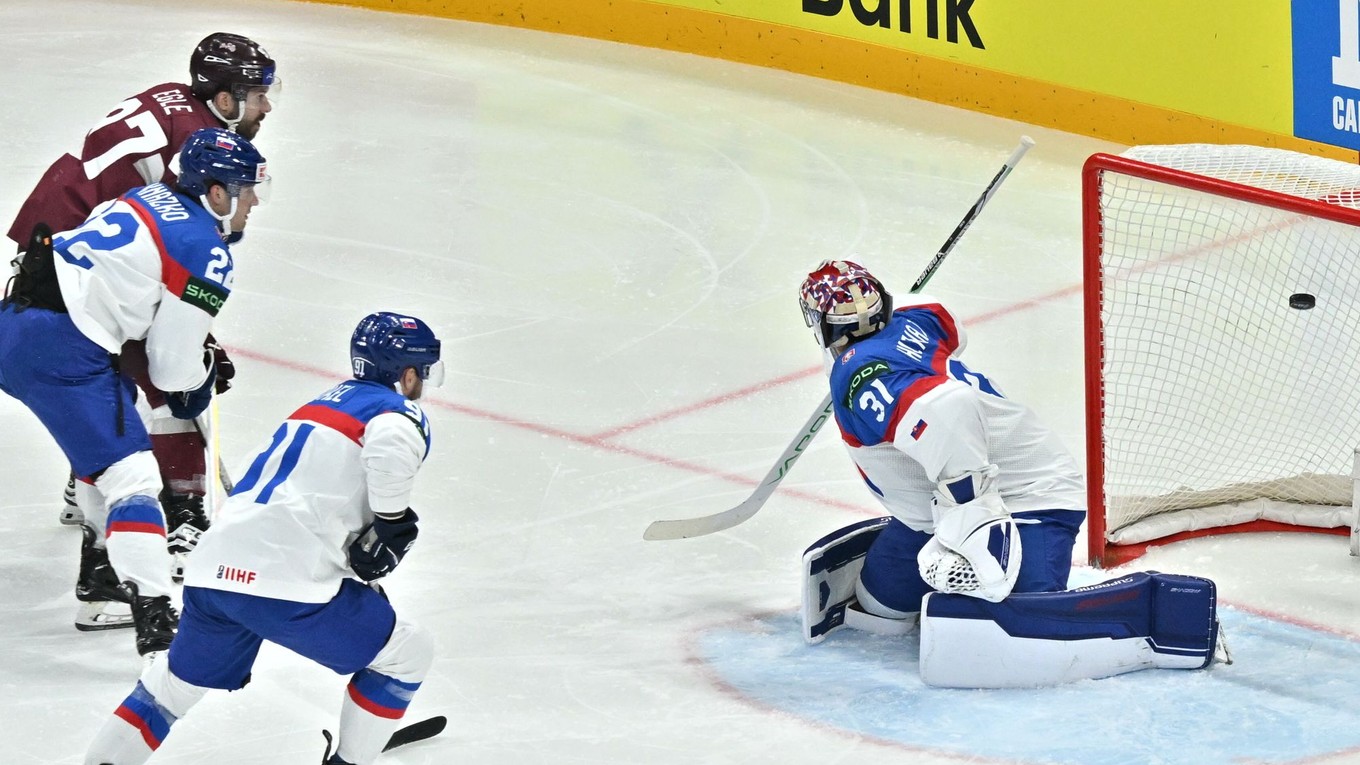 Brankár Samuel Hlavaj inkasuje gól, ktorý strieľa Haralds Egle v zápase Slovensko - Lotyšsko v skupine A na MS v hokeji 2025.