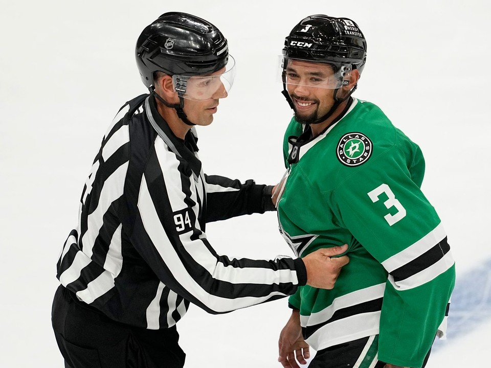 Rozhodca Bryan Pancich a hráč Dallasu Stars Matt Dumba.