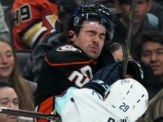 Brett Leason z Anaheimu je narazený na mantinel Vincom Dunnom zo Seattlu.