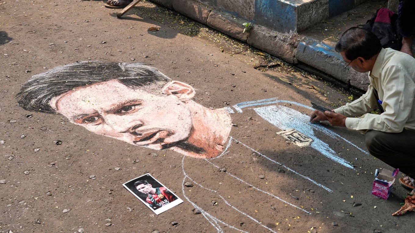 Indický umelec Swapan Das maľuje portrét argentínskej futbalovej hviezdy Lionela Messiho na ulici v očakávaní jeho návštevy.