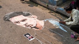 Indický umelec Swapan Das maľuje portrét argentínskej futbalovej hviezdy Lionela Messiho na ulici v očakávaní jeho návštevy.