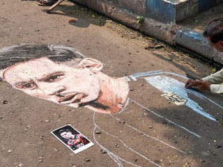 Indický umelec Swapan Das maľuje portrét argentínskej futbalovej hviezdy Lionela Messiho na ulici v očakávaní jeho návštevy.