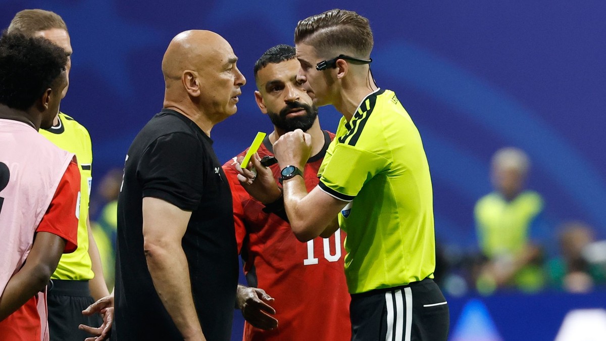 Tréner egyptskej futbalovej reprezentácie Hossam Hassan dostáva žltú kartu od rozhodcu Francoisa Letexiera