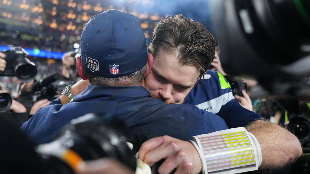 Quarterback tímu Seattle Seahawks Sam Darnold v objatí s trénerom Mikeom MacDonaldom. 