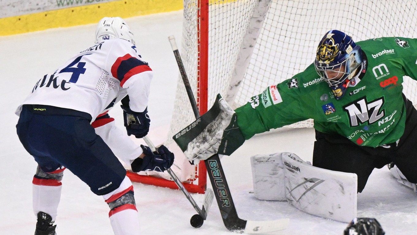 Mitchell Hoelscher a brankár Christopher Gibson v zápase HC Nové Zámky - HC Slovan Bratislava v 28. kole Tipos extraligy.