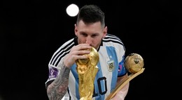 Lionel Messi bozkáva trofej pre víťaza MS vo futbale.