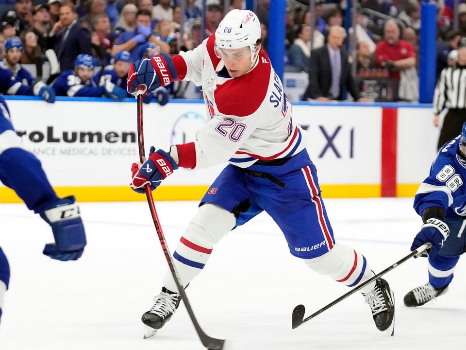 Juraj Slafkovský (uprostred) strieľa gól, vpravo ho bráni hráč Tampy Nikita Kučerov