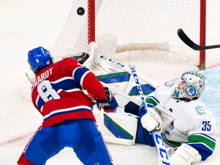 Ben Chiarot z Montrealu Canadiens neúspešne strieľa na brankára Vancouveru Canucks Thatchera Demka.