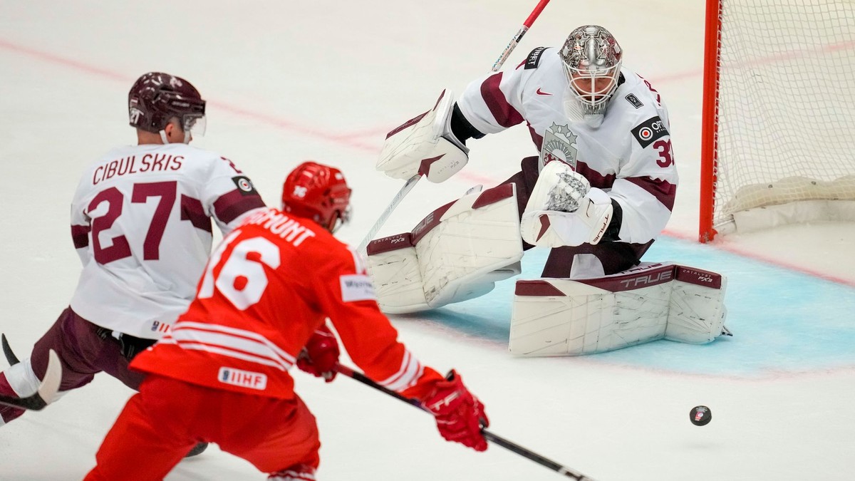 Zákrok lotyšského brankára Elvisa Merzlikinsa v zápase Poľsko - Lotyšsko na MS v hokeji 2024.