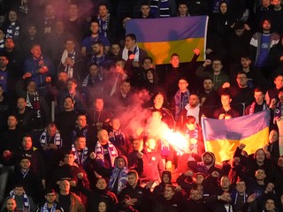 Fanúšikovia Dinama Záhreb zapaľujú svetlice a držia ukrajinské vlajky počas odvety play off osemfinále Európskej ligy vo futbale Dinamo Záhreb - FC Sevilla.