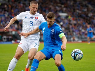 Denis Vavro (vľavo) v súboji o loptu s kapitánom Islandu Johannom Bergom Guomundssonom počas kvalifikačného zápasu Island - Slovensko na EURO 2024. 