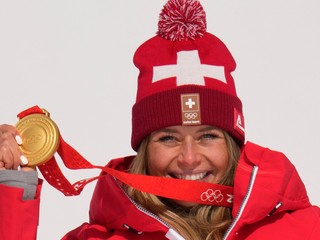 Švajčiarka Corinne Suterová pózuje so zlatou medailou za triumfe v zjazde na ZOH 2022.