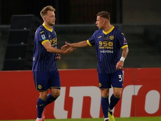 Hráč Casper Tengstedt (vľavo) z Verony sa raduje z gólu, vpravo Slovák Tomáš Suslov (31) počas zápasu.