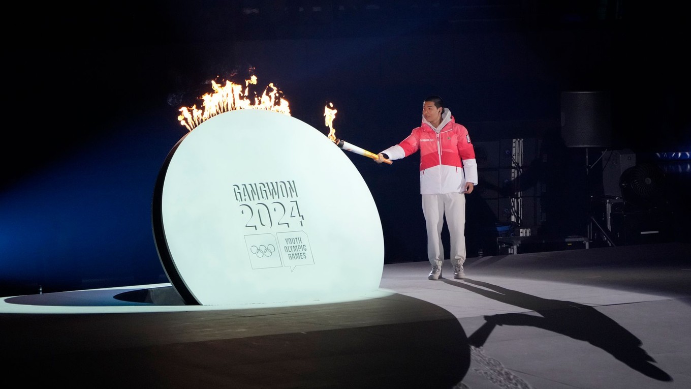 Akrobatický lyžiar Lee Jeong-min zapaľuje olympijský oheň počas otváracieho ceremoniálu.