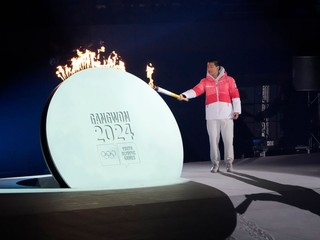 Akrobatický lyžiar Lee Jeong-min zapaľuje olympijský oheň počas otváracieho ceremoniálu.