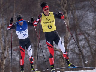 Kanadský bežec na lyžiach Brian Mckeever so svojim navádzačom. 