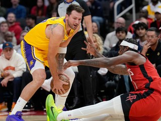 Tari Eason z Houston Rockets (vpravo) padá pri bránení hráča Luka Dončič z Los Angeles Lakers.
