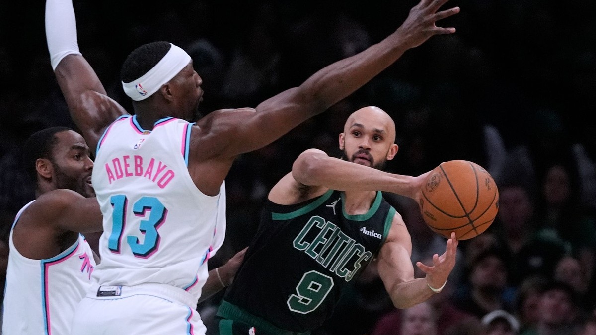 Obranca Bostonu Celtics Derrick White (9) hľadá možnosť prihrávky, zatiaľ čo ho bráni pivot Miami Heat Bam Adebayo (13).