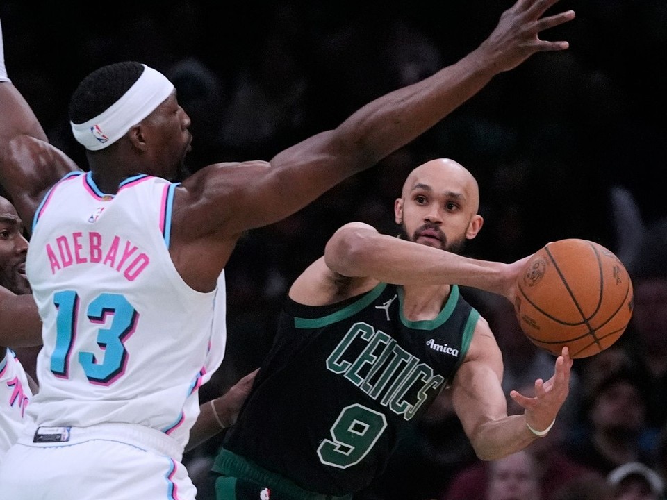Obranca Bostonu Celtics Derrick White (9) hľadá možnosť prihrávky, zatiaľ čo ho bráni pivot Miami Heat Bam Adebayo (13).