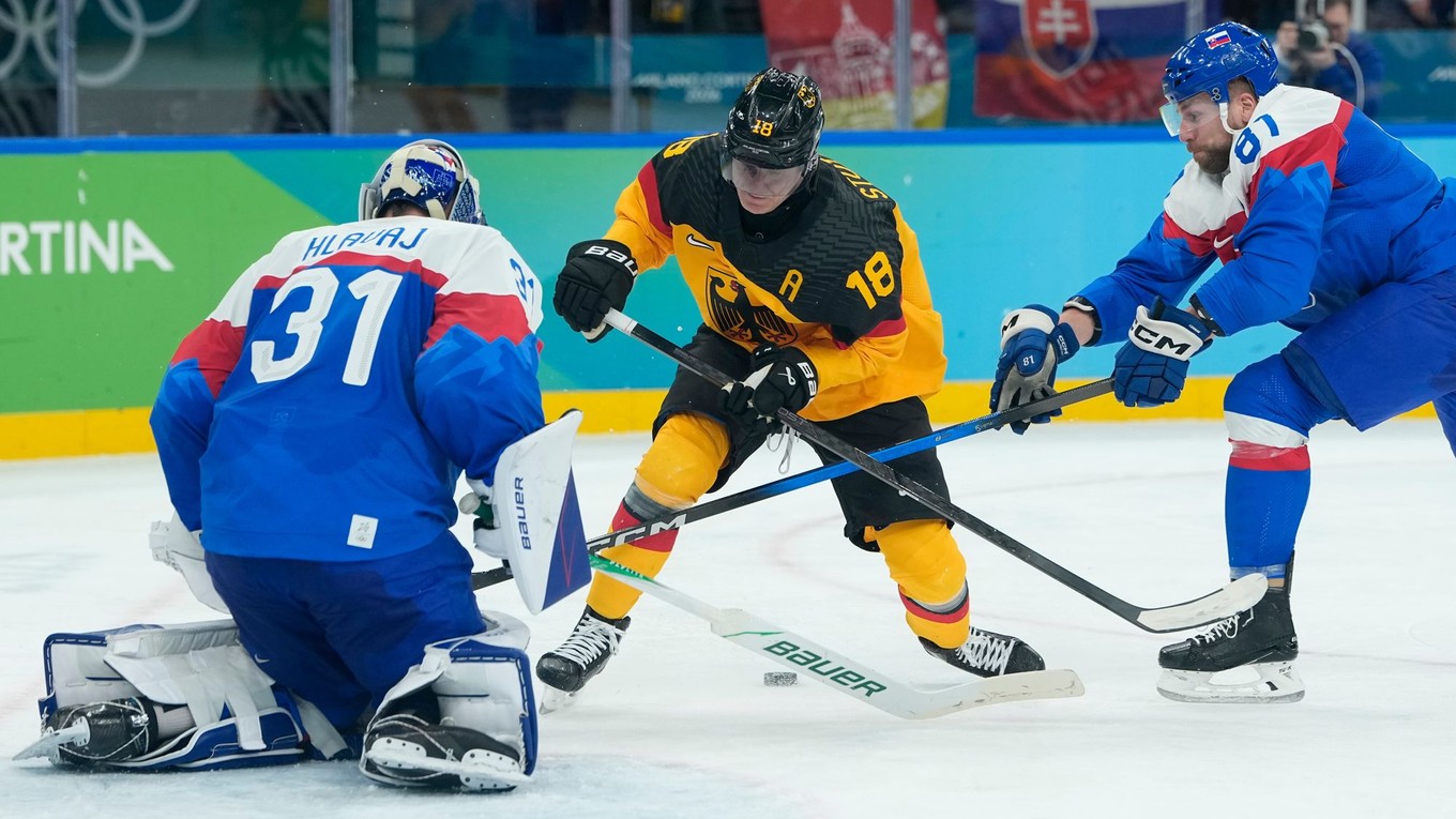 Erik Černák bráni nemeckého útočníka Tima Stützleho v zápase Slovensko - Nemecko na ZOH 2026.