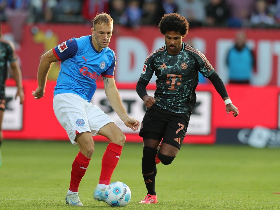 Slovenský obranca Dominik Javorček a Serge Gnabry v zápase Holstein Kiel - Bayern Mníchov.  