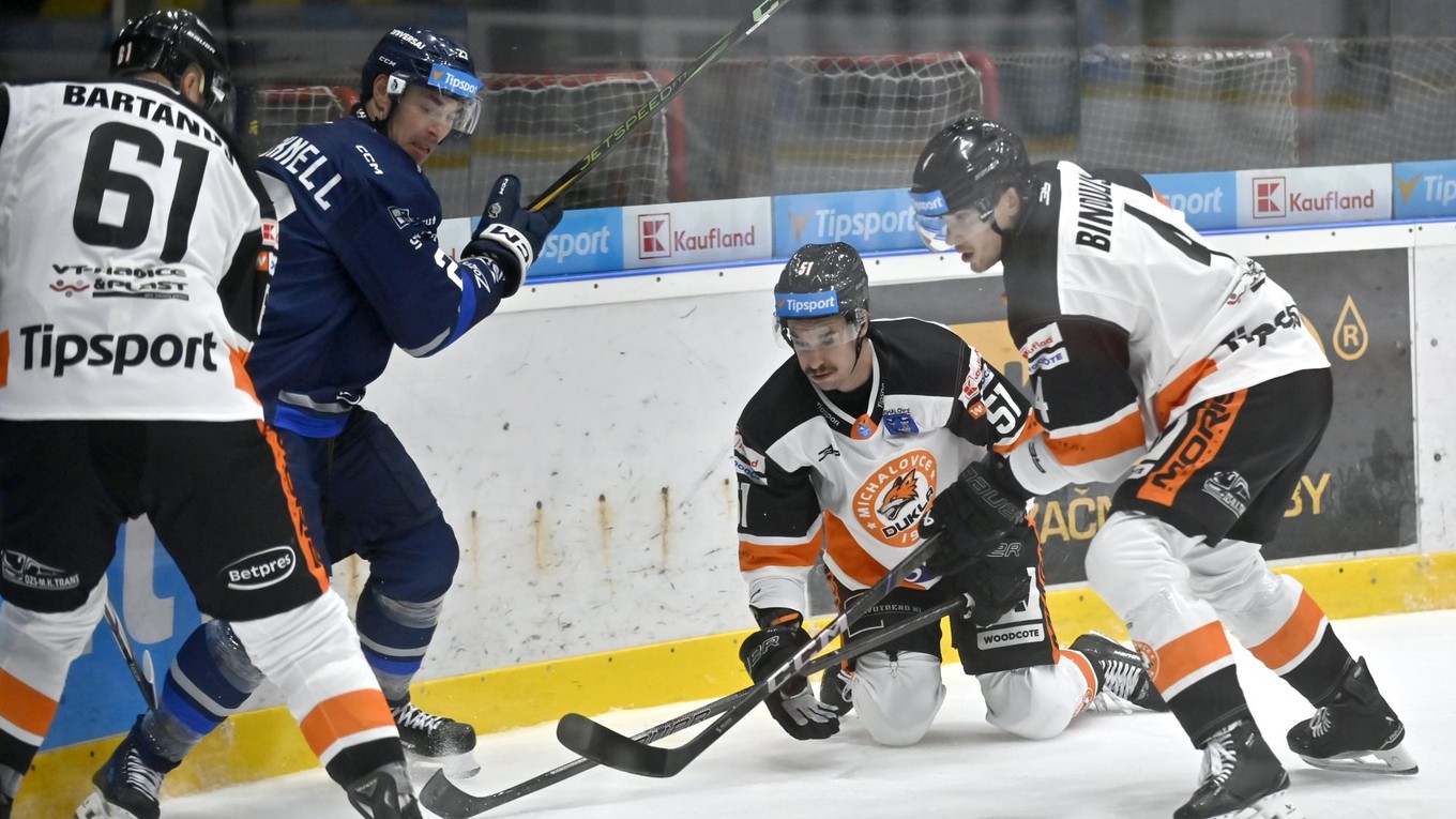 Vľavo Marek Bartánus, tretí zľava Joordan Martell a vpravo Kristofers Bindulis (všetci Michalovce) a druhý zľava Adam Cracknell (Poprad) bojujú puk