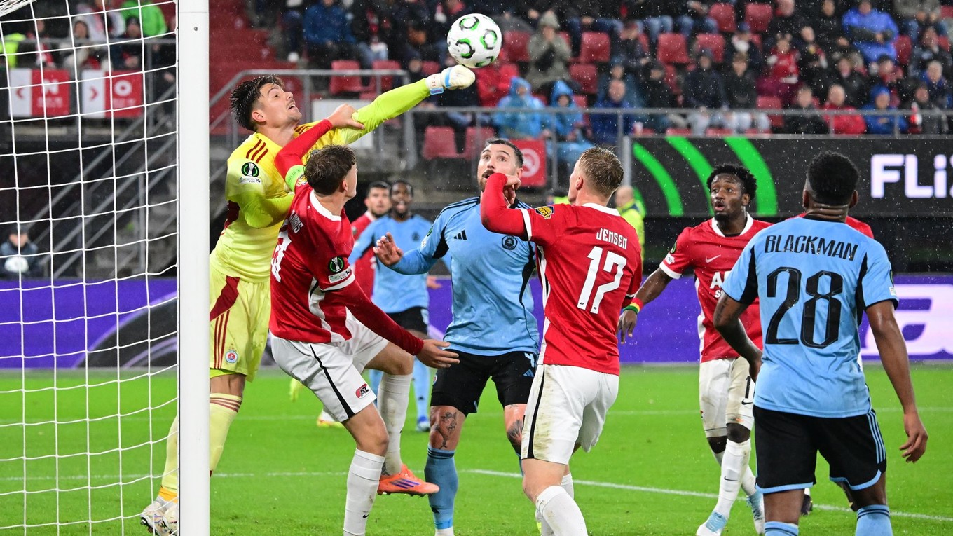 Brankár Slovana Dominik Takáč (vľavo) vyráža loptu počas zápasu 2. kola ligovej fázy Konferenčnej ligy vo futbale AZ Alkmaar - ŠK Slovan Bratislava. 