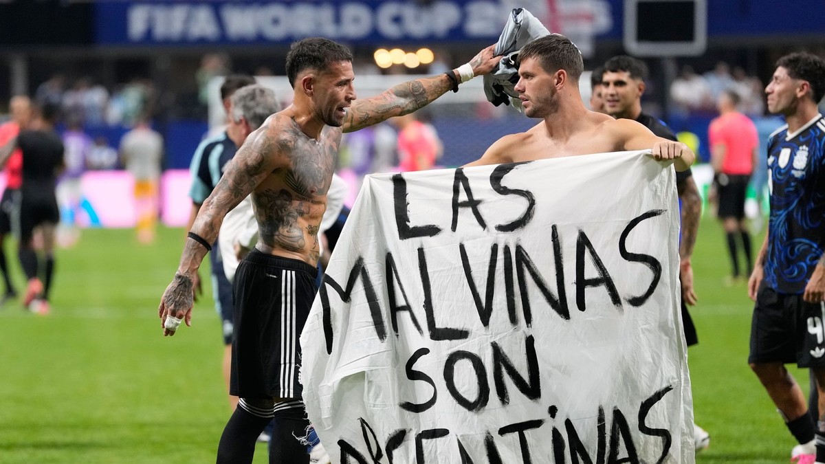 Argentínčan Giovani Lo Celso drží transparent s nápisom „Malvíny patria Argentíne“.