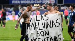 Argentínčan Giovani Lo Celso drží transparent s nápisom „Malvíny patria Argentíne“.