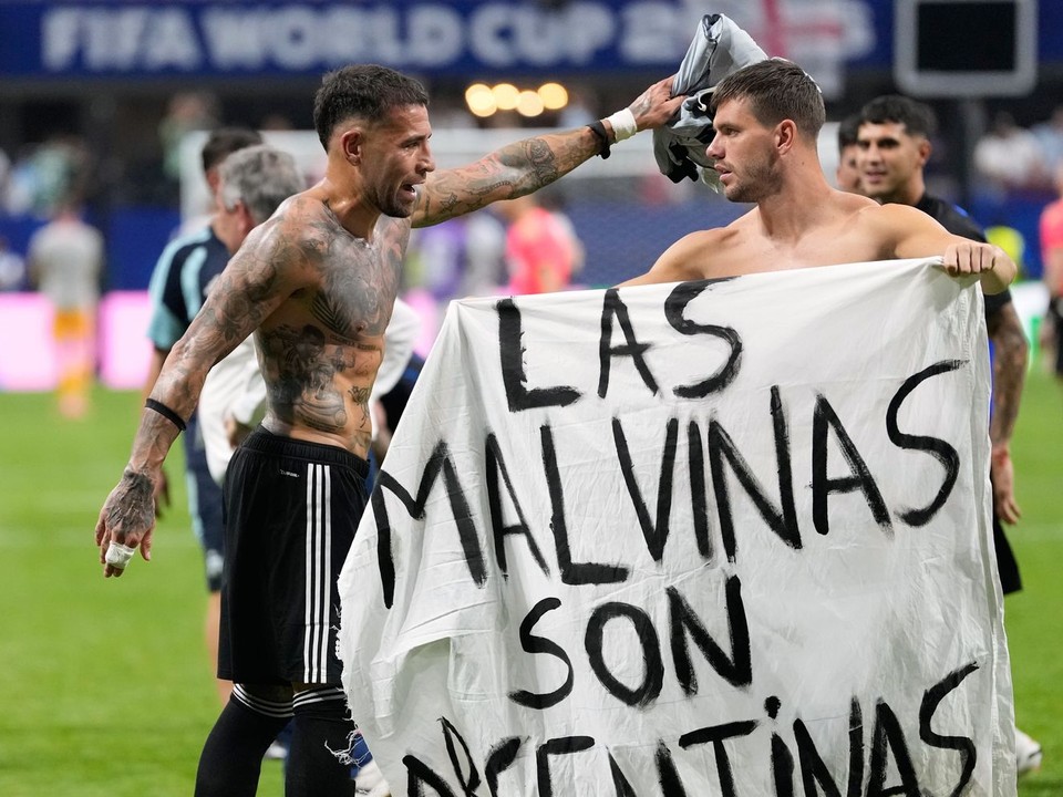 Argentínčan Giovani Lo Celso drží transparent s nápisom „Malvíny patria Argentíne“.