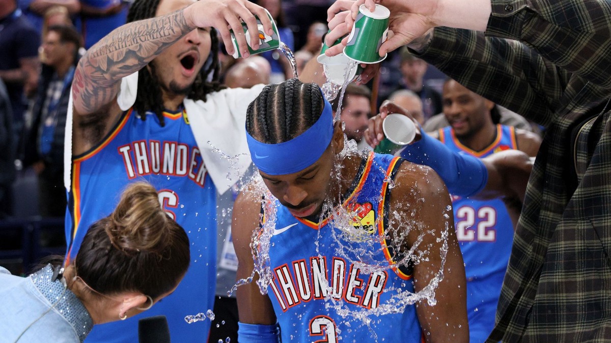 Jaylin Williams vľavo a ďalší hráči Thunder polievajú vodou rozohrávača Shai Gilgeous-Alexander (2) po zápase.