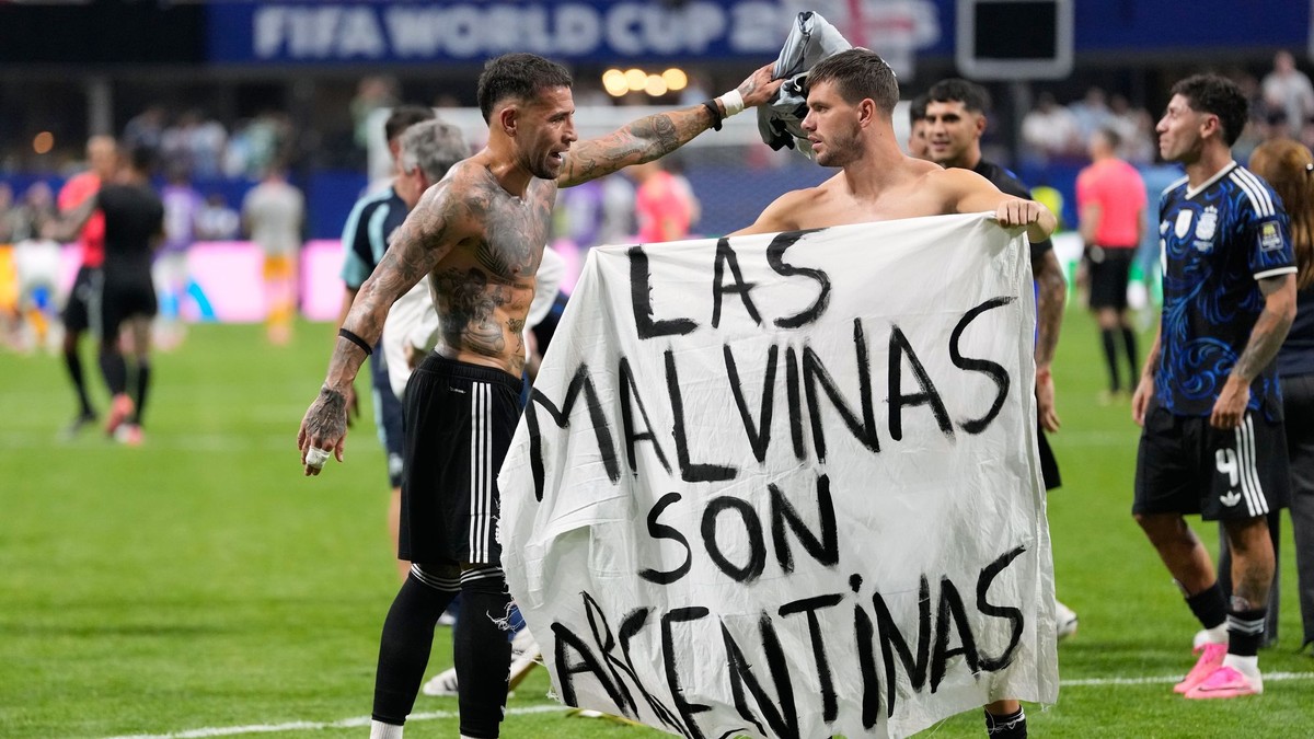Argentínski futbalisti s bannerom s nápisom: "Falklandy sú Argentína."