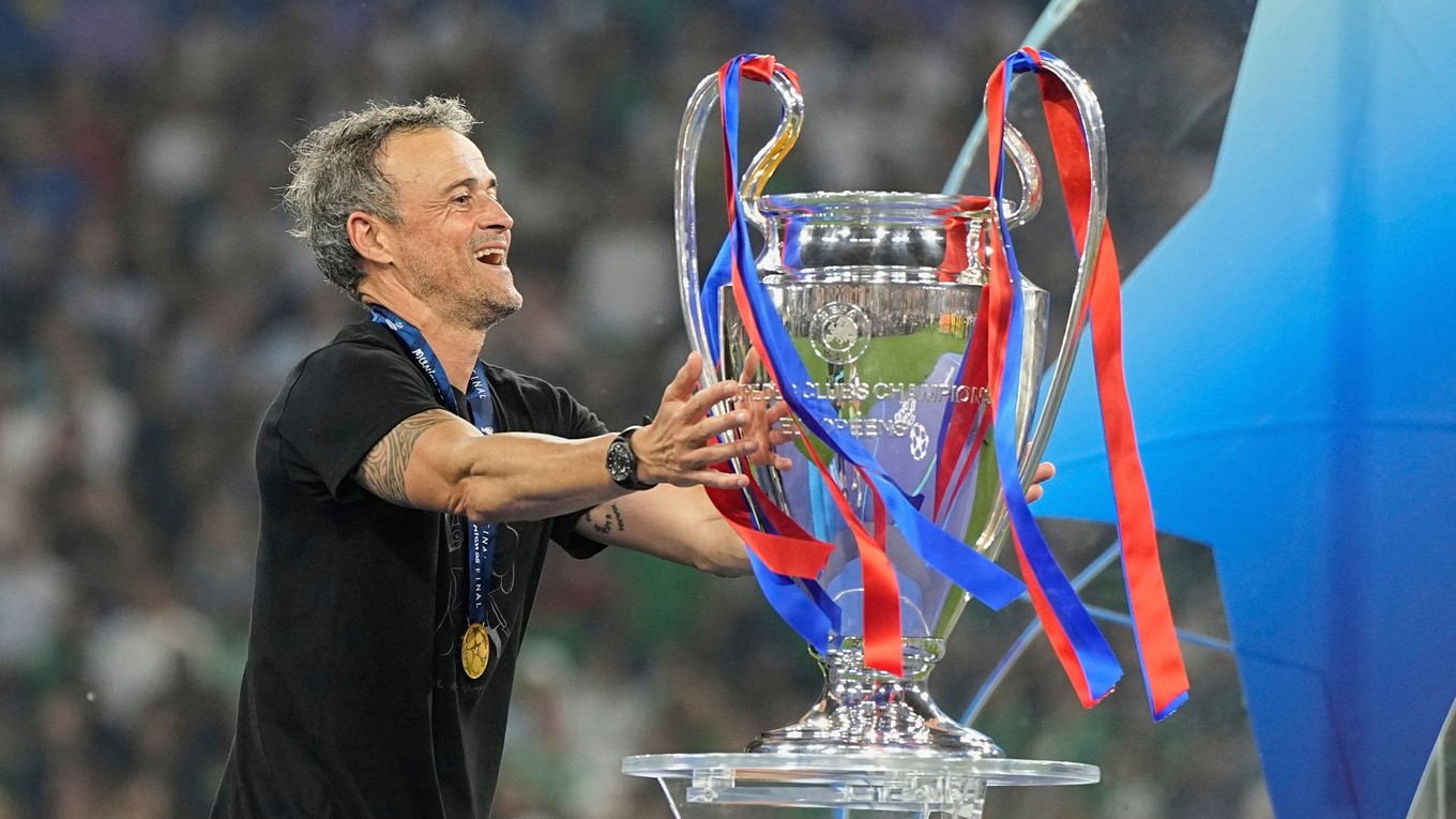 Tréner PSG Luis Enrique sa dotýka trofeje po triumfe vo finále Ligy majstrov.