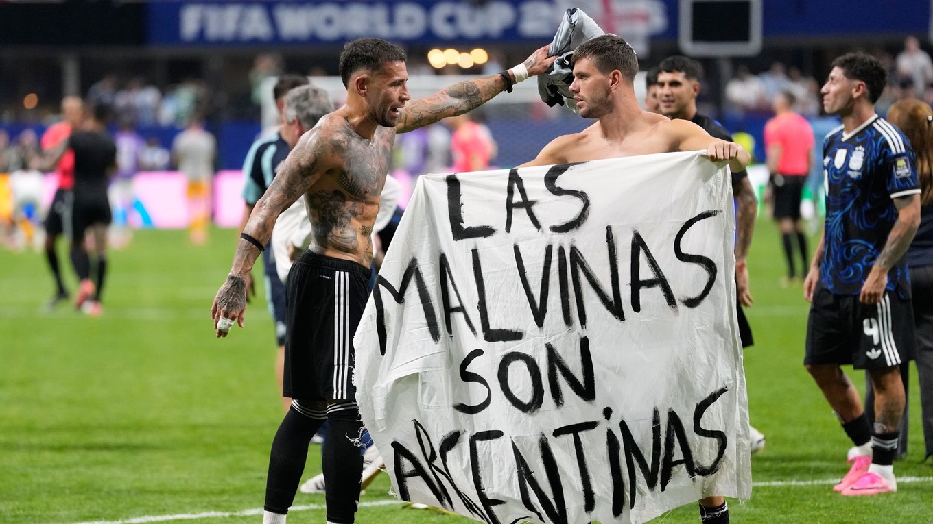 Argentínski futbalisti s bannerom s nápisom: "Falklandy sú Argentína."