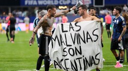 Argentínski futbalisti s bannerom s nápisom: "Falklandy sú Argentína."
