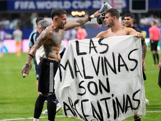 Argentínski futbalisti s bannerom s nápisom: "Falklandy sú Argentína."