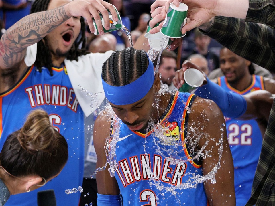 Jaylin Williams vľavo a ďalší hráči Thunder polievajú vodou rozohrávača Shai Gilgeous-Alexander (2) po zápase.