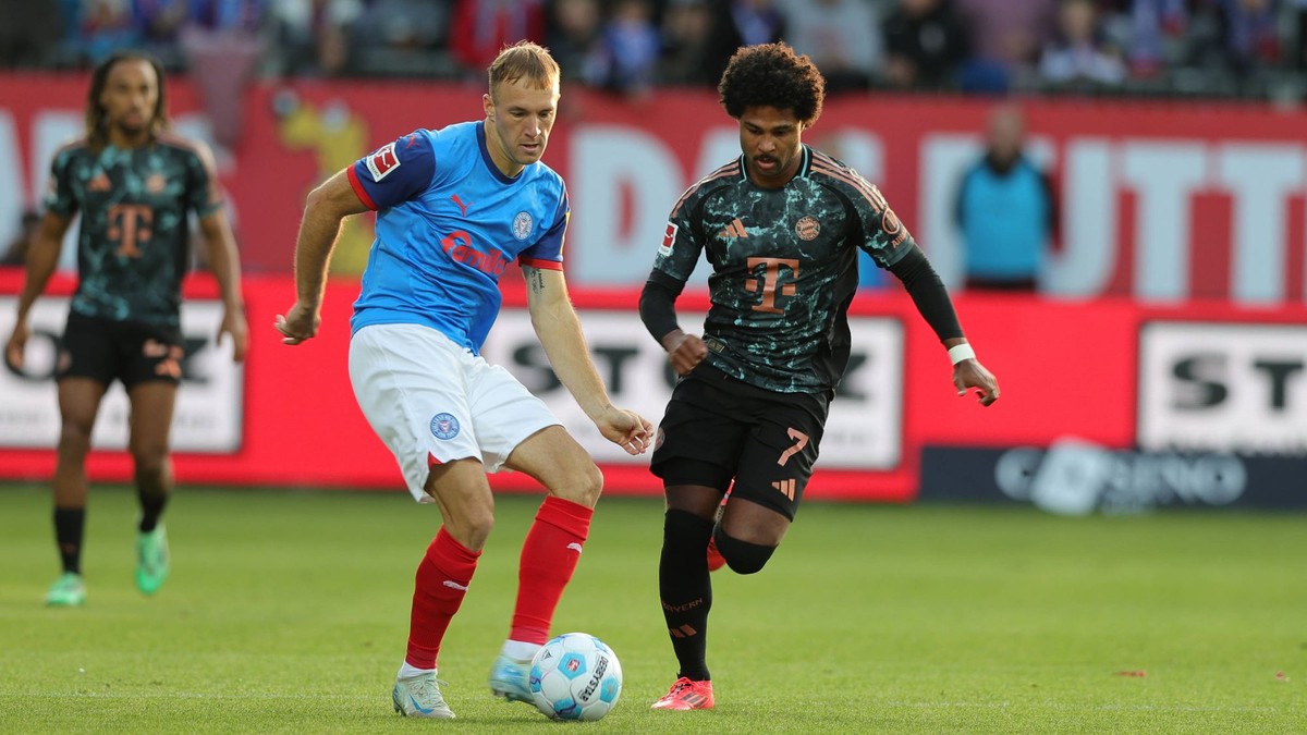 Slovenský obranca Dominik Javorček a Serge Gnabry v zápase Holstein Kiel - Bayern Mníchov.  