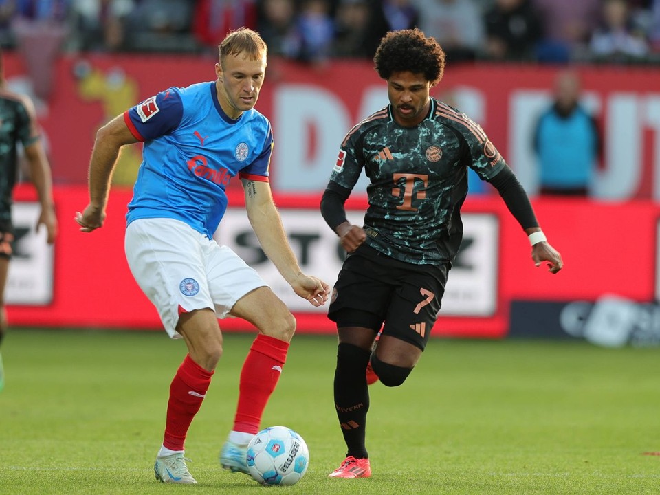 Slovenský obranca Dominik Javorček a Serge Gnabry v zápase Holstein Kiel - Bayern Mníchov.  