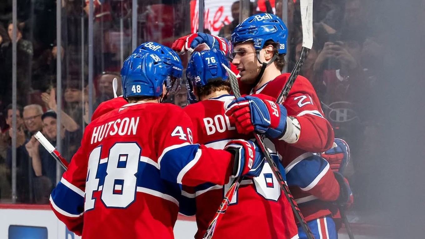 Juraj Slafkovský oslavuje gól so spoluhráčmi.