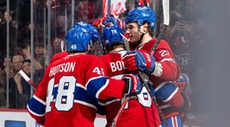 Juraj Slafkovský oslavuje gól so spoluhráčmi. 