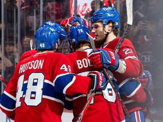 Juraj Slafkovský oslavuje gól so spoluhráčmi.