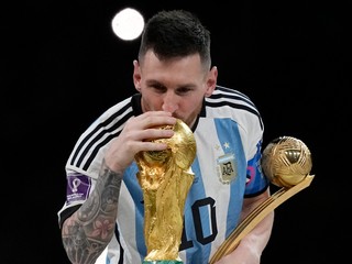 Lionel Messi bozkáva trofej pre víťaza MS vo futbale.