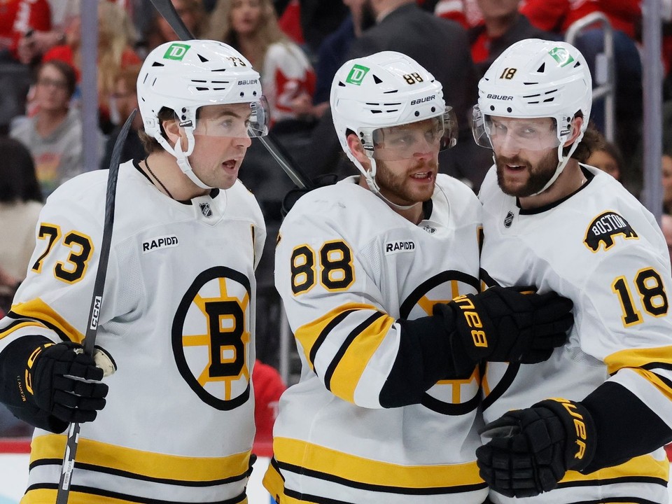 David Pastrňák (88) oslavuje svoj gól proti Detroitu spolu s obrancom Charlie McAvoy (73) a Pavlom Zachom (18).