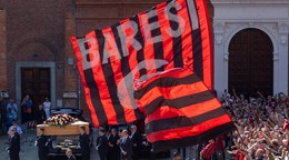 Pri rakve bývalej futbalovej legendy Franca Baresiho vlaje na námestí pred Bazilikou svätého Ambróza počas pohrebného obradu obrovská vlajka AC Miláno.
