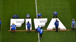 Na snímke pracovníci umiestňujú na trávnik nápis Medzinárodnej futbalovej federácie (FIFA).