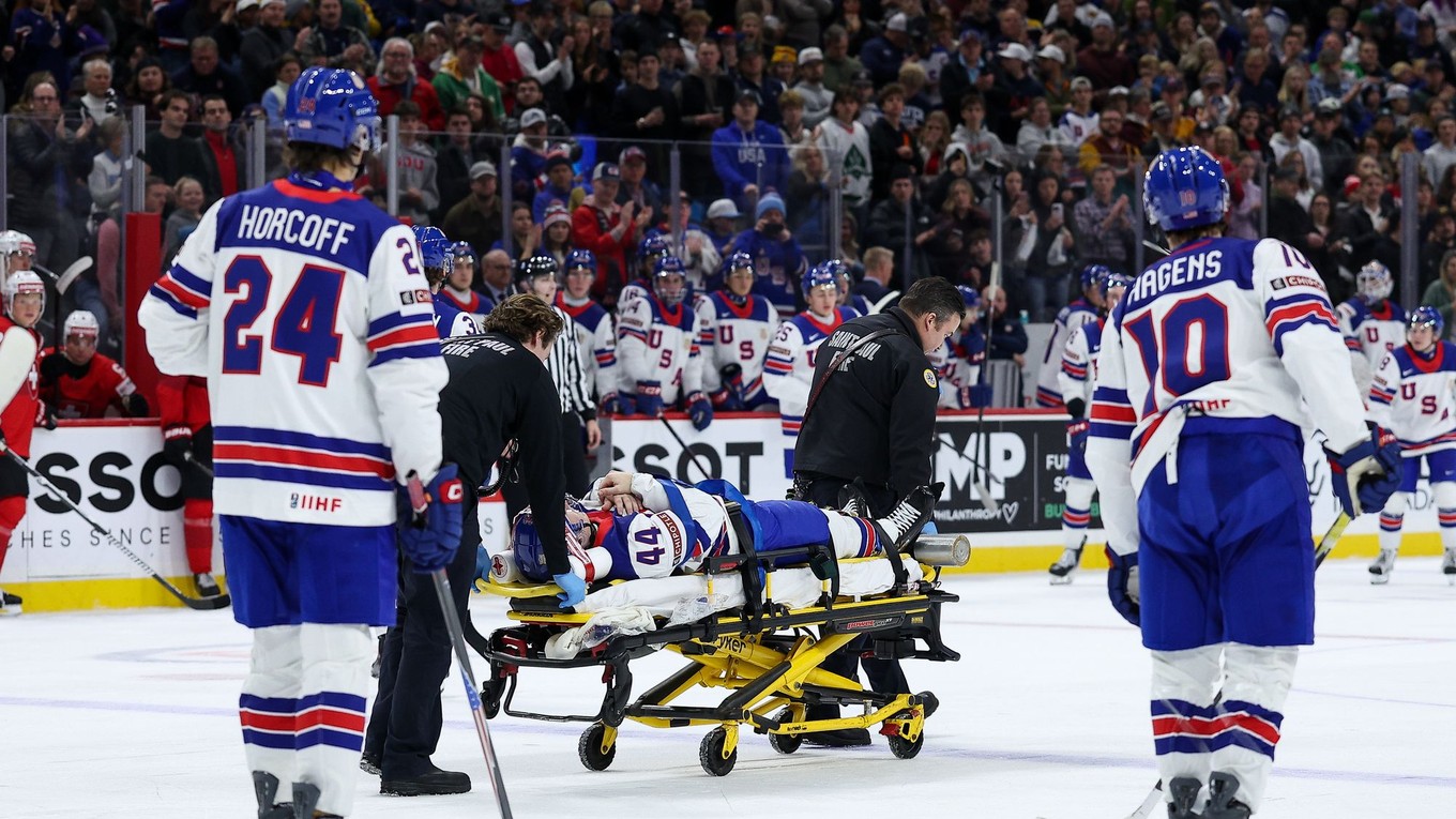 Cole Hutson na nosidlách po údere pukom.